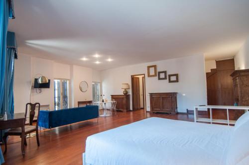 a bedroom with a white bed and a dining room at Umbrian Concierge - Duomo Accommodations in Perugia