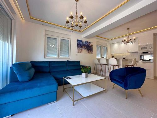 salon z niebieską kanapą i stołem w obiekcie Apartments Infinity w mieście Tivat