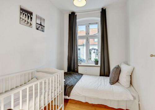 - un lit bébé blanc dans une chambre avec fenêtre dans l'établissement Two Bedroom Apartment In Aarhus, Ole Rmers Gade 104, à Aarhus