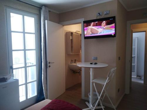 a room with a bathroom with a tv on the wall at AFFITTACAMERE PIAZZA UNITA' in Monfalcone