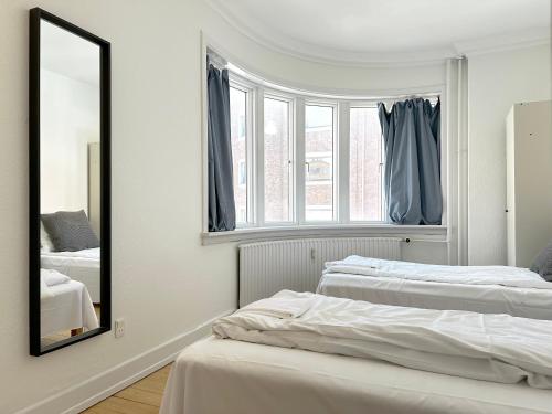 a bedroom with two beds and a mirror at Nice Apartment Located Near Vesterbro in Aalborg