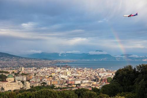 a plane flying over a city with a rainbow at Terrazza Paradiso Luxury Rooftop in Naples
