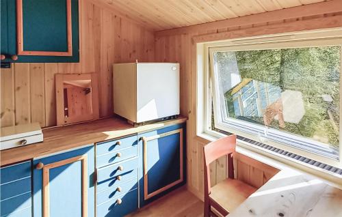 eine Küche mit einem Kühlschrank und einem Fenster in der Unterkunft Lovely Home In Flateby With Kitchen in Flateby