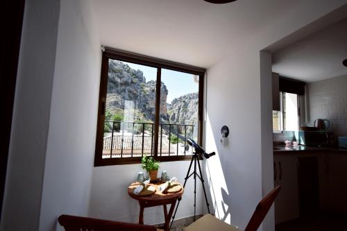 a room with a window and a table with a camera at EL HECHIZO DEL BAILÓN in Zuheros