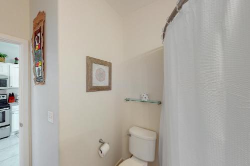 a bathroom with a toilet and a shower curtain at Laguna Jewel in Port Isabel
