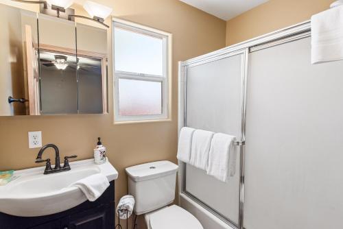 een badkamer met een toilet, een wastafel en een douche bij Nana Bear Manor - Quiet and spacious log cabin with hot tub perfect for a mountain getaway! in Big Bear City