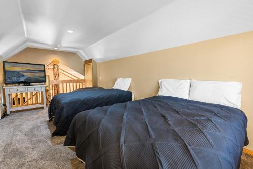 zwei Betten in einem Zimmer mit Fernseher und Balkon in der Unterkunft Nana Bear Manor - Quiet and spacious log cabin with hot tub perfect for a mountain getaway! in Big Bear City
