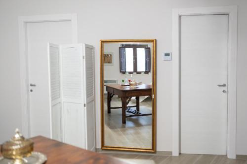 a mirror in a room with a table and a desk at B&b Antica Dimora in Chiaromonte