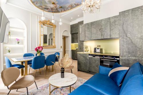 een woonkamer met een blauwe bank en een tafel bij Luxury 2 Bedroom 1 Bathroom - Louvre Museum & Opera in Parijs