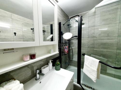 un bagno con lavandino e doccia in vetro di Acrey 