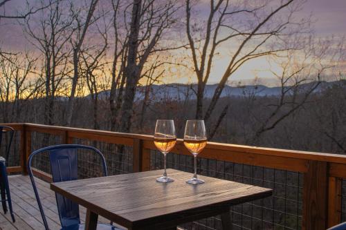 セバービルにあるEntire cabin in Sevierville, Tennesseeの木製テーブル、バルコニーのワイン2杯
