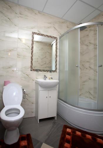 a bathroom with a toilet and a sink and a shower at Kompleks Perła in Łomża
