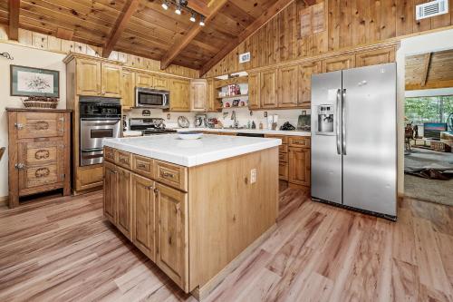 a kitchen with wooden cabinets and a stainless steel refrigerator at Catalina Retreat -Cozy mountain home in a tree filled neighborhood, plenty of games and a hot tub! in Big Bear Lake