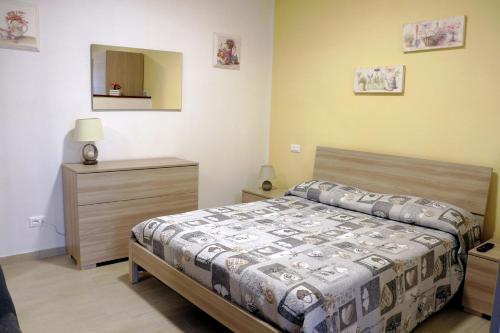 a bedroom with a bed and a dresser and a mirror at Appartamenti l'Olivo in Bagnone