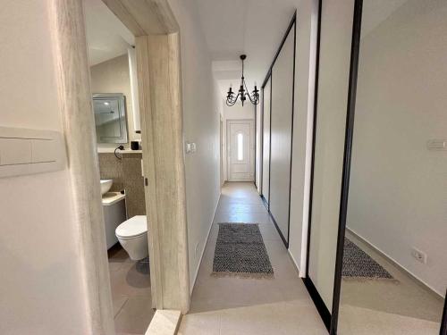 un corridoio che conduce a un bagno con servizi igienici di Apartments Infinity a Tivat