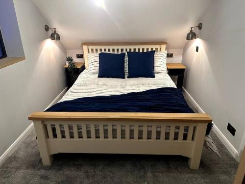 a large bed with blue pillows in a bedroom at The Annex Glastonbury Tor View in Glastonbury