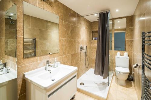 y baño con lavabo, aseo y ducha. en Elegant 2BD Duplex with Outdoor Patio/Glass Canopy, en Londres