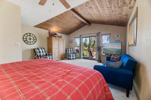 een slaapkamer met een rood bed en een aantal stoelen bij Lakeview Haven - Large cabin with game room close to the lake! in Big Bear Lake