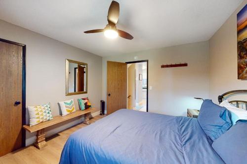 um quarto com uma cama azul e uma ventoinha de tecto em Ridgeline Panorama em Truckee