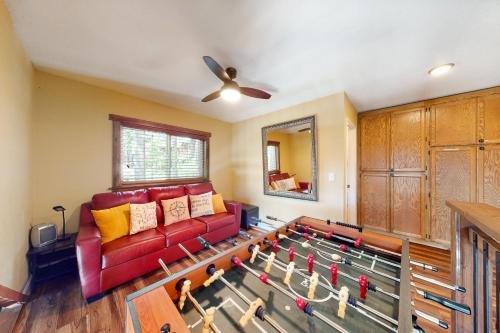 a living room with a red couch and a table with toy guns at Ridgeline Panorama in Truckee