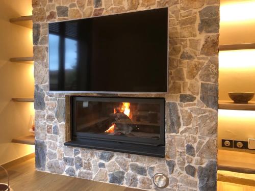 a fireplace with a tv on top of it at Villagio inn Suite & Spa in Soúlion