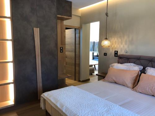 a bedroom with a bed with white sheets and pillows at Villagio inn Suite & Spa in Soúlion