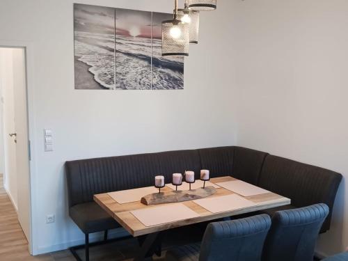 a dining room table with a picture on the wall at Ferienhaus Seehuis, Sauna, angeln, familienfreundlich in Twist