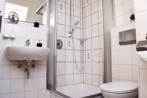 uma casa de banho com um chuveiro, um WC e um lavatório. em Wattwürmchen em Wremen