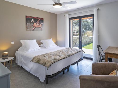 une chambre avec un grand lit et une fenêtre dans l'établissement Figuiers, à Beaumes-de-Venise