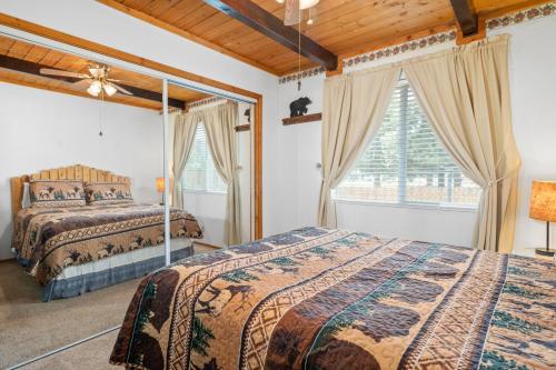 Un dormitorio con dos camas y una ventana. en Lazy Bear Cabin -Beautiful mountaineer style cabin with wood ceilings and beamed accents, en Big Bear City
