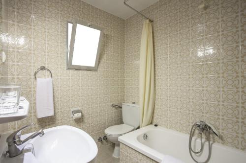 a bathroom with a toilet and a sink and a tub at Casual de la Música Valencia in Valencia