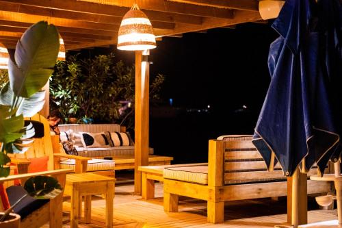 a patio with chairs and tables and a umbrella at Torbahan Hotel in Torba