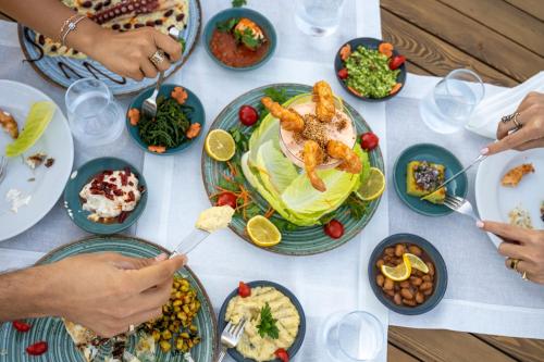 a table full of plates of food with seafood on it at Torbahan Hotel in Torba