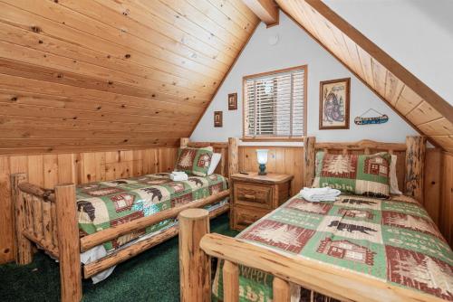 a bedroom with two beds in a log cabin at Juniper's Cottage - Secluded hideaway with a large fenced yard giving the feeling of privacy! in Big Bear City