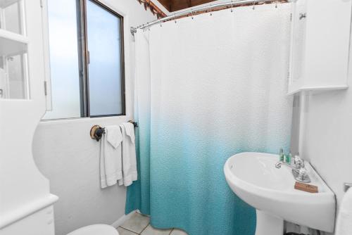 a bathroom with a shower curtain and a sink at Juniper's Cottage - Secluded hideaway with a large fenced yard giving the feeling of privacy! in Big Bear City