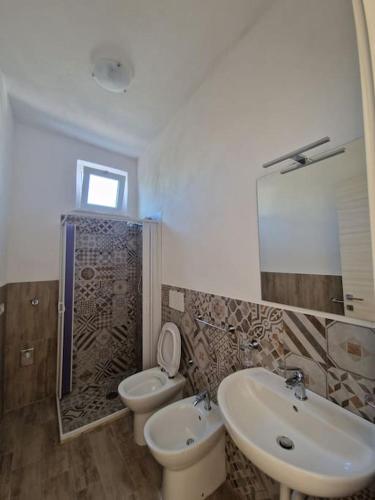 a bathroom with a sink and a toilet and a mirror at Casa Forio d'Ischia in Ischia