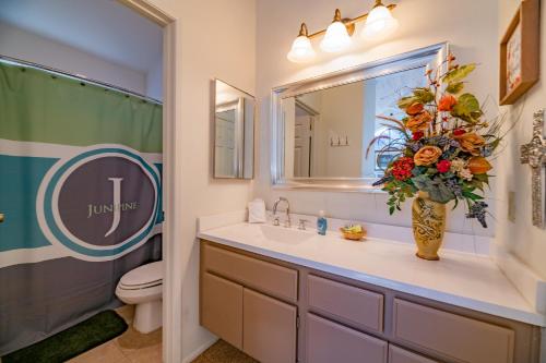a bathroom with a sink and a vase of flowers at Junipine Lakefront Condo - Walking distance to the lake! Less than 2 miles from the slopes! in Big Bear Lake