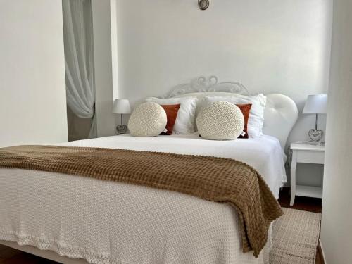 a white bed with two pillows on top of it at Casa Santiago & Mafalda Lux Home in Olhão