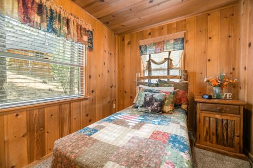 - une chambre avec un lit et un mur en bois dans l'établissement Cozy on Rainbow - Delightful property in a quite residential area! Perfect mountain getaway!, à Big Bear City