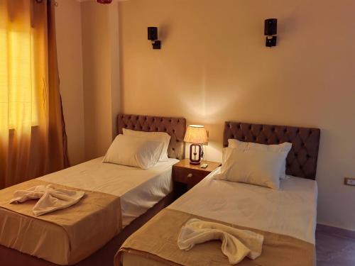 a bedroom with two beds and a lamp on a table at Gem Overlooking inn in Cairo