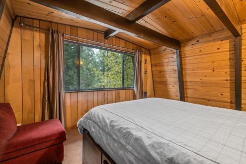 ビッグ・ベアー・レイクにあるComfy Cubby - Cozy mountain home in a great location near Bear Mountain Ski Resortのベッドルーム1室(ベッド1台付)、キャビン内の窓