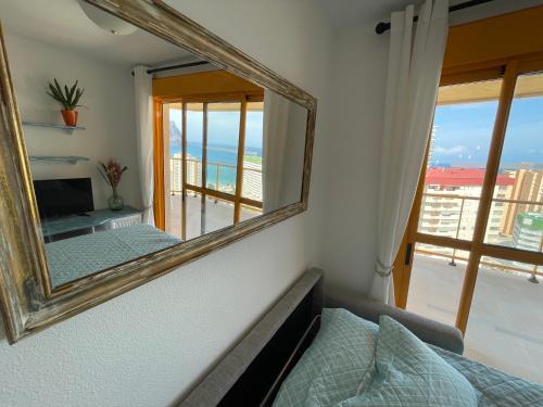 a mirror on the wall of a room with a couch at Apto One More Day in Ambar in Calpe