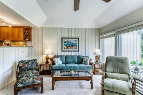 a living room with a blue couch and chairs at Manualoha 203 in Koloa