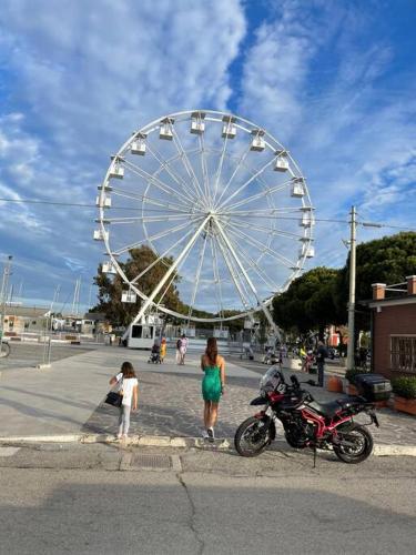 a woman and a child standing in front of a wheel at “Il Centro” Nel cuore, a due passi dal mare in Giulianova