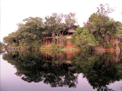 a house on a hill next to a body of water at Gondwana Namushasha River Lodge in Kongola