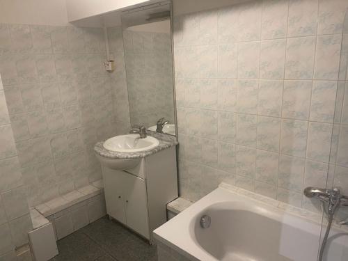 a bathroom with a sink and a bath tub at Hotel de la Gare in Châteauroux