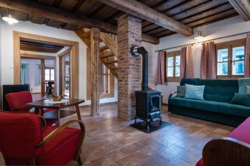 a living room with a fireplace and a green couch at Chalupa Bocza in Nižná Boca