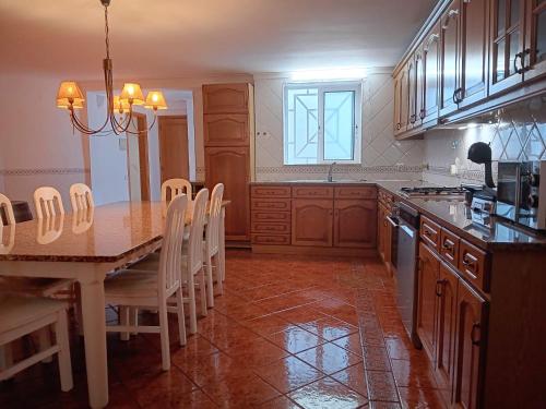 a kitchen with a wooden table and a dining room at Alma Rustica in Albufeira