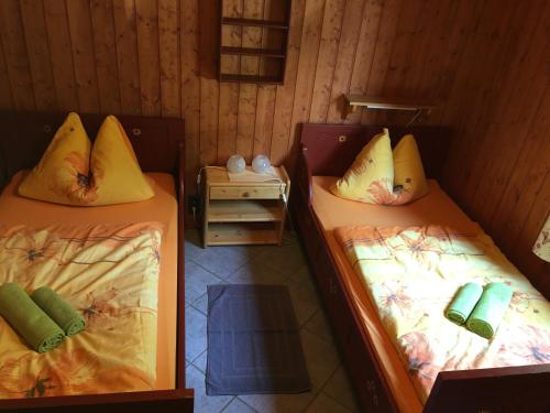 two twin beds in a room with a table at Ferienhaus Am Wäldchen in Weiskirchen