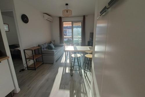- une cuisine et un salon avec une table et des tabourets dans l'établissement Apartment with pool near the beach, à La Seyne-sur-Mer
